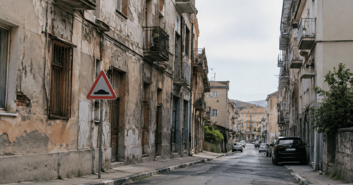 Rue urbaine avec immeubles délabres et panneaux danger visibles