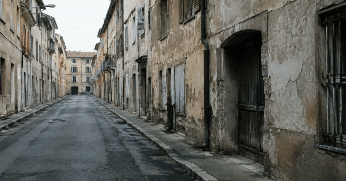 Rue urbaine déserte avec immeubles dégradés et façades ternies