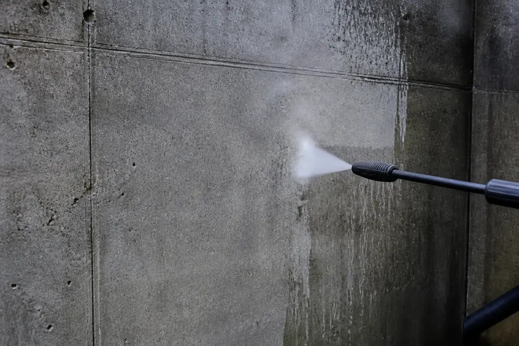 Mur en beton gris ruisselant sous jet haute pression